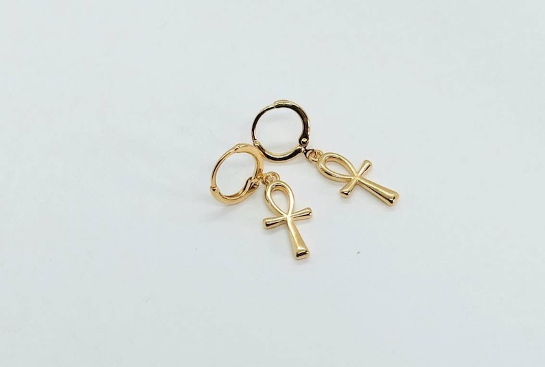 Op de afbeelding: Een paar gouden creolen met een ankh-bedel die aan elke creool hangt.