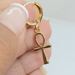 Op de afbeelding: Gouden creolen oorring met een hangende ankh bedel. De ankh is een symbool van leven en eeuwig leven in de oude Egyptische religie.