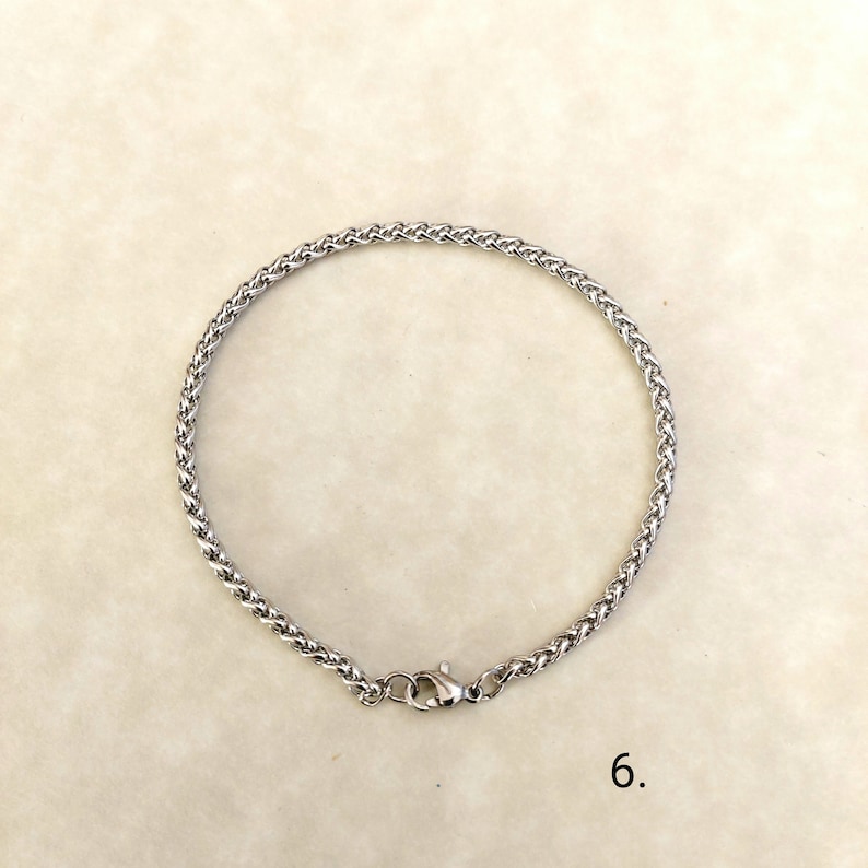May include: A silver chain bracelet with a lobster clasp closure.
