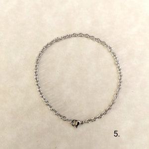 May include: A silver chain bracelet with a lobster clasp closure.