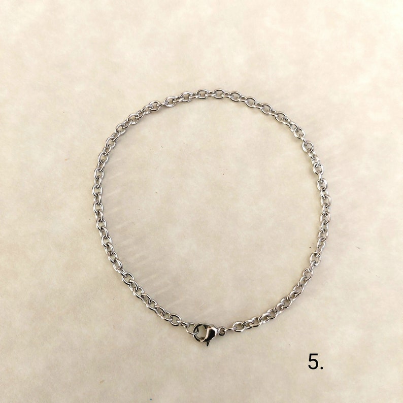 May include: A silver chain bracelet with a lobster clasp closure.