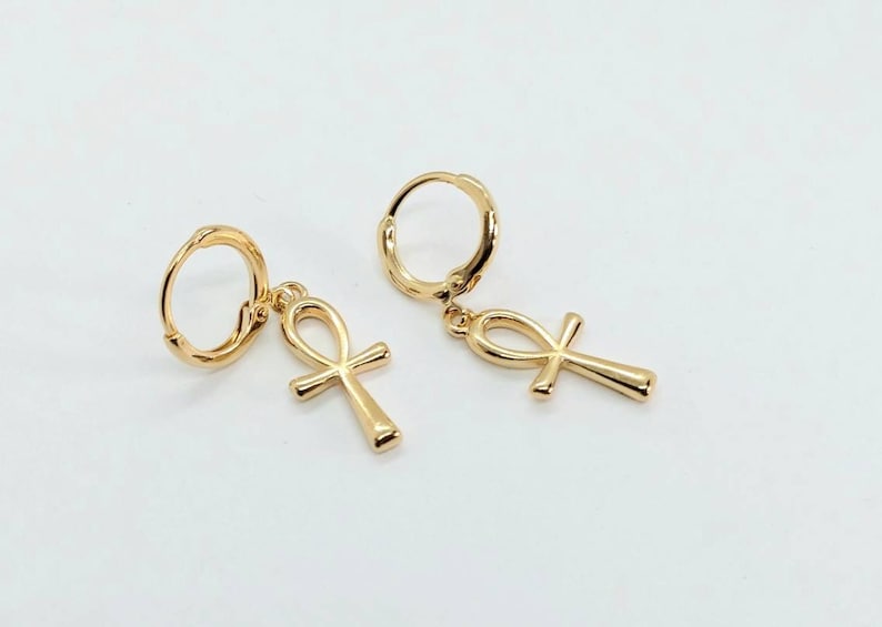 Op de afbeelding: Een paar gouden creolen met een ankh-bedel die aan elke creool hangt.