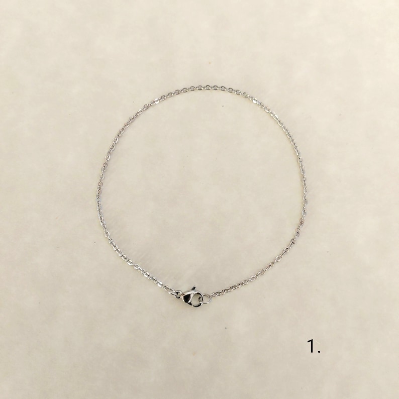 May include: A silver chain necklace with a lobster clasp.