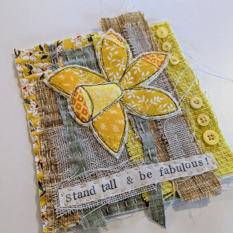 May include: A white ceramic mug with a black handle and the text "But First, Coffee" in a black, handwritten-style font. The mug is on a white surface.