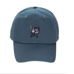May include: A teal blue baseball cap with an embroidered cartoon character holding a crescent moon.