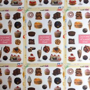 May include: Sticker sheets with illustrations of desserts, including waffles, cupcakes, and ice cream cones. The sheets also feature the phrases "sweet treat" and "I'm in need of a sweet treat" in a pink box. The stickers are colorful.