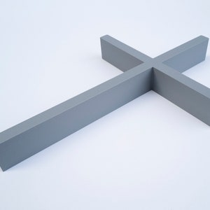 Peut inclure: Une croix en bois grise avec un design simple. La croix est faite d'une seule pi&egrave;ce de bois et a une finition lisse.