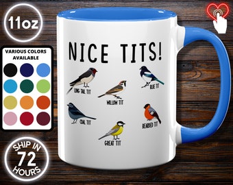 May include: White ceramic mug with a blue interior and handle, featuring the text "NICE TITS!" and illustrations of various bird species, including Long Tail Tit, Willow Tit, and Blue Tit. The mug is labeled as 11oz and has a color selection chart.