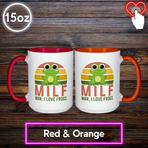 May include: Two 15oz white ceramic mugs with red and orange handles and interiors. Each mug features a green frog graphic with the text "MILF, MAN, I LOVE FROGS" against a sunset background. The bottom of the image reads "Red & Orange".