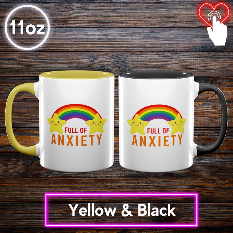 May include: Two 11oz white ceramic mugs with the text "FULL OF ANXIETY" under a rainbow and star design. One mug has a yellow interior and handle, the other has a black interior and handle. The bottom of the image reads "Yellow & Black".