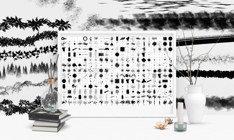 May include: A white framed poster with a grid of black and white brushstrokes, shapes, and patterns. The poster is on a white surface with a vase, a candle, and a stack of books.