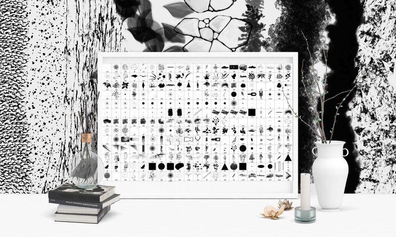 May include: A black and white poster with a grid of various brush strokes and shapes. The poster is framed in a white frame and is hanging on a white wall. There are a few decorative items on the table in front of the poster, including a vase with a branch, a candle, and a glass bottle.