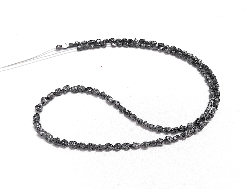 May include: A strand of black rough diamond beads, strung on a thin wire.