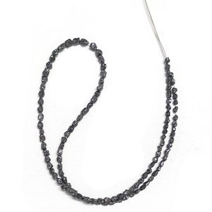 May include: A strand of black rough diamond beads, strung on a thin wire. The beads are irregular in shape and have a matte finish.