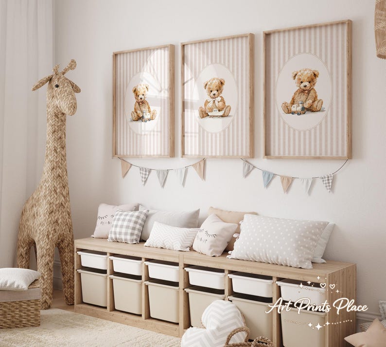May include: Three framed prints featuring watercolor teddy bears on a striped background. The prints are in a nursery setting, with a woven giraffe, storage bench, and decorative pillows. The color palette is soft and neutral.
