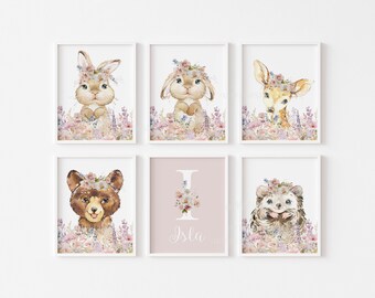 May include: A set of six framed watercolour prints. The prints depict woodland creatures, including a rabbit, bunny, deer, bear, and hedgehog, all wearing floral crowns. The prints are set against a backdrop of pastel flowers and foliage, with a personalized print featuring the letter "I" and the name "Isla".