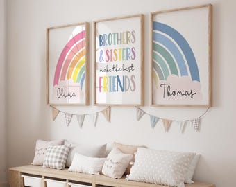 May include: Three framed art prints with rainbows and names. One print says "Brothers & Sisters make the best FRIENDS". The other two prints have a rainbow design and the names "Olivia" and "Thomas". A garland of small flags hangs below the prints.