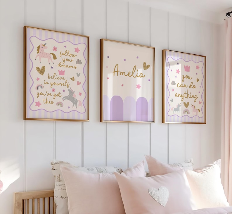 May include: Three framed wall art pieces with gold frames. The art features unicorns, hearts, stars, and text that reads "follow your dreams", "believe in yourself", "you've got this", "Amelia", and "you can do anything". The color palette includes lavender, gold, and cream.