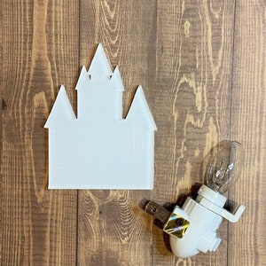 May include: White plastic castle-shaped nightlight with a white plug-in cord and a clear light bulb.