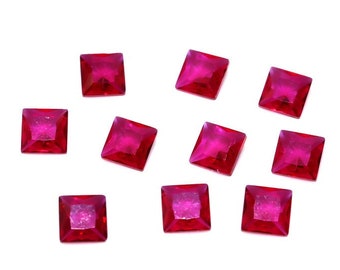 May include: Ten square-shaped, ruby red, faceted rhinestones.