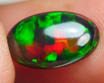 May include: A dark green and red opal gemstone with a smooth, polished surface.