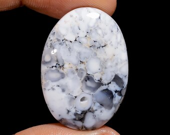May include: White and grey oval cabochon with a swirling pattern of white, grey, and black. The cabochon has a smooth, polished surface.