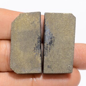 May include: Two rectangular pieces of rough, dark grey stone with a gold flecked surface.