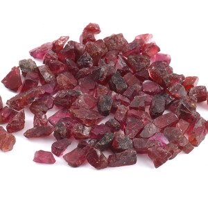 K&ouml;nnte beinhalten: Ein Haufen roher, roter Rubin-Edelsteine. Die Rubinkristalle sind in verschiedenen Gr&ouml;&szlig;en und Formen.