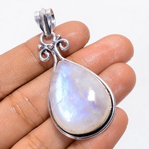 May include: A pear-shaped moonstone pendant with a silver-colored bail and decorative flourishes. The moonstone has a milky white base with iridescent blue and purple flashes. The pendant is approximately 2 inches long.
