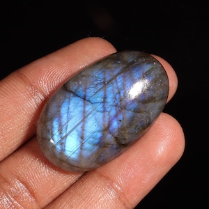May include: A large, oval-shaped, blue labradorite gemstone with iridescent flashes of colour.