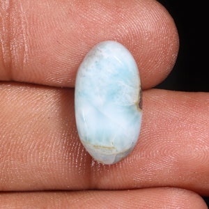 May include: Oval shaped blue and white gemstone with a cloudy, marbled pattern. The gemstone has a smooth, polished surface.