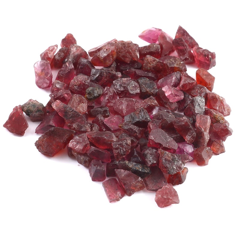 K&ouml;nnte beinhalten: Ein Haufen loser, grob geschnittener, rosafarbener und roter Edelsteine. Die Edelsteine sind in verschiedenen Gr&ouml;&szlig;en und Formen.