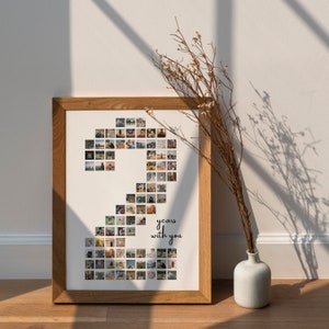 May include: A framed photo collage in a light brown frame. The collage is made up of small square photos arranged in the shape of the number 2. The text "2 years with you" is printed below the number.