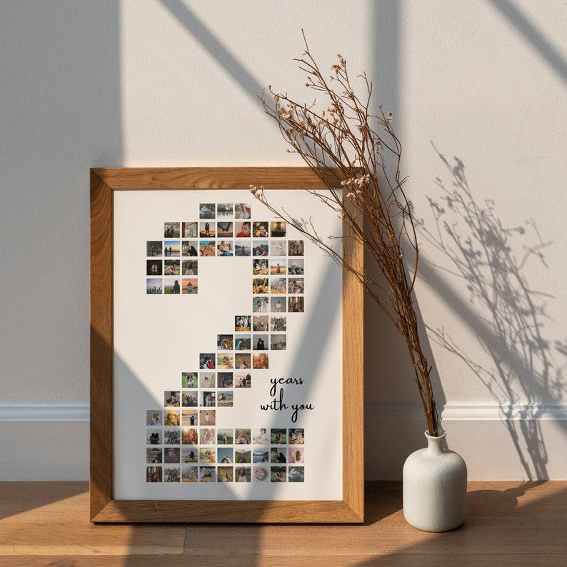 May include: A framed photo collage in a light brown frame. The collage is made up of small square photos arranged in the shape of the number 2. The text "2 years with you" is printed below the number.