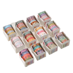 May include: Assortment of colorful washi tape rolls in various patterns, including floral, geometric, and abstract designs. The tape rolls are arranged in a grid pattern on a white surface.