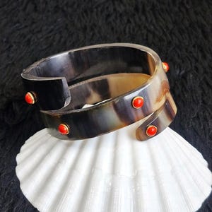 Bracciale rigido a forma di serpente in corno di bufalo, placcato oro 18 carati, con dettagli in corallo.