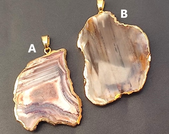 May include: Two agate pendants with gold-plated edges. The pendant on the left is a light brown with white and pink stripes. The pendant on the right is a darker brown with white stripes. Both pendants have a gold bail for hanging.