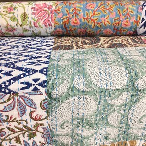 Peut inclure: Une courtepointe patchwork avec une variété de motifs floraux et paisley dans des tons de bleu, vert, rose et blanc. La courtepointe est faite de tissu de coton et est cousue à la main.