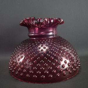 May include: A purple glass lampshade with a ruffled top and a textured, bubbled surface.