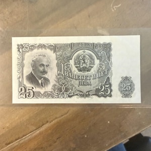 May include: A 25 Leva banknote from the People's Republic of Bulgaria. The note features a portrait of a man on the left, with ornate designs and text in Cyrillic. The number 25 appears multiple times on the note.