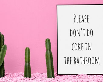 May include: A white sign with black text that reads "PLEASE DON'T DO COKE IN THE BATHROOM" against a pink wall with three green cactus plants in front of it.