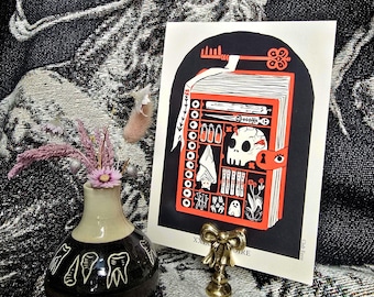 May include: A black and red illustrated print of a book with a skull and other spooky objects. The book is open and has a key sticking out of it. The print is on a white background and has the text "XXIX STORE" at the bottom.