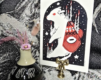 May include: A white rabbit with red eyes stands on a black background with a red and white design behind it. The rabbit is surrounded by candles with flames. The image is titled "Club Eerie".