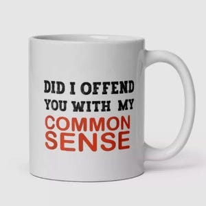 May include: White ceramic coffee mug with black text that reads "Did I offend you with my common sense" with the word "sense" in red.