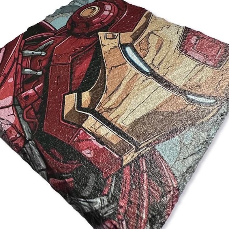 K&ouml;nnte beinhalten: Ein quadratischer Untersetzer aus Schiefer mit einer detaillierten Illustration von Iron Mans Helm und Schulterpanzerung. Das Kunstwerk verwendet Farbt&ouml;ne von Rot, Gold und Grau im Comic-Stil.