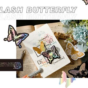 May include: A close-up of a book with several iridescent butterfly stickers on the pages. The stickers are in various colours, including pink, blue, green, and gold. The text on the page reads "Handmade for you" and "Inspiration".