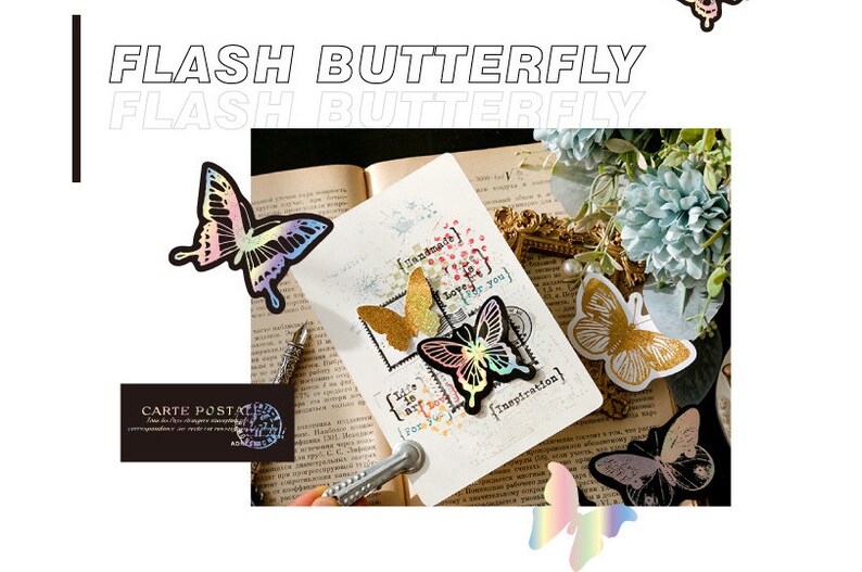 May include: A close-up of a book with several iridescent butterfly stickers on the pages. The stickers are in various colours, including pink, blue, green, and gold. The text on the page reads "Handmade for you" and "Inspiration".