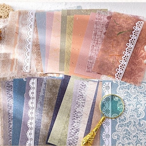 May include: A collection of decorative papers with lace trim. The papers are in various shades of blue, green, and brown. The lace trim is white and has a delicate floral pattern.
