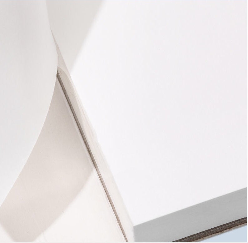 May include: A close-up of a white surface with a subtle shadow. The surface appears to be smooth and reflective.