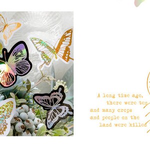May include: A bouquet of flowers with iridescent butterfly stickers. The butterflies are in various colours and designs, including gold, silver, and rainbow.